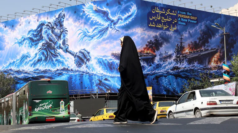 una-mujer-irani-camina-junto-a-una-valla-publicitaria-antiestadounidense-en-la-plaza-enghelab-de-teheran-foto-efeabedin-taherkenareh-RF6BM2B2D5HVLDBPYZENLZKUQU